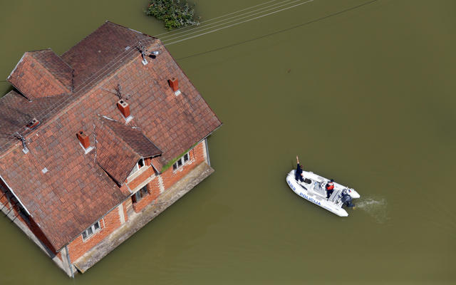 Flooded House Overseen By A Police Boat