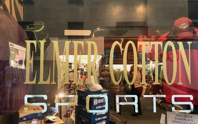 Looking through the window of Elmer Cotton Sports, with the name printed on the window