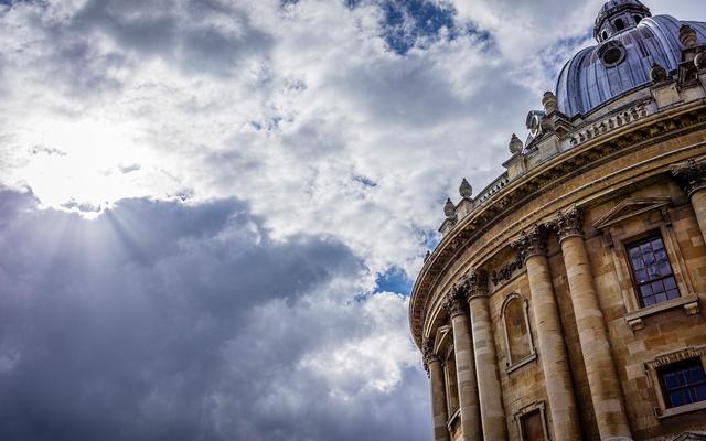 A view from groundlevel to the roof of the Radcliffe Camera, with a dark, cloudy sky behind it