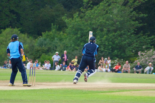 Cricket match in University Parks with players batting and spectators watching from the boundary