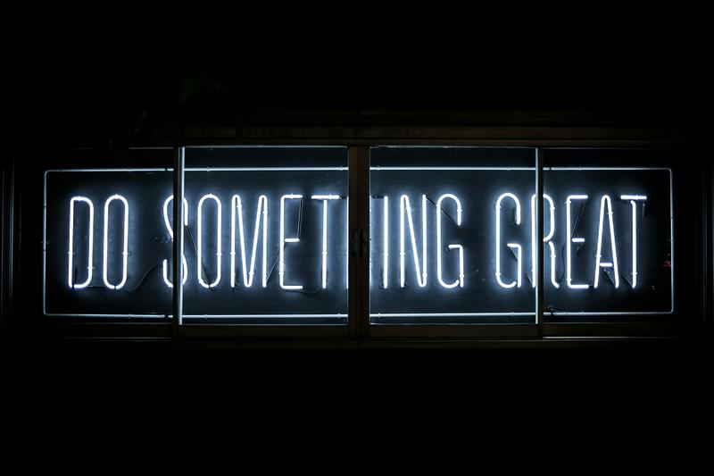 A neon lit word sign that reads 'Do Something Great'