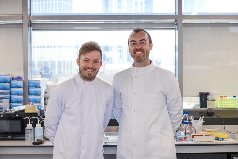 Dan Hansen and Mark Wilkinson, co-founders of Bactobio, stand together in white laboratory suits