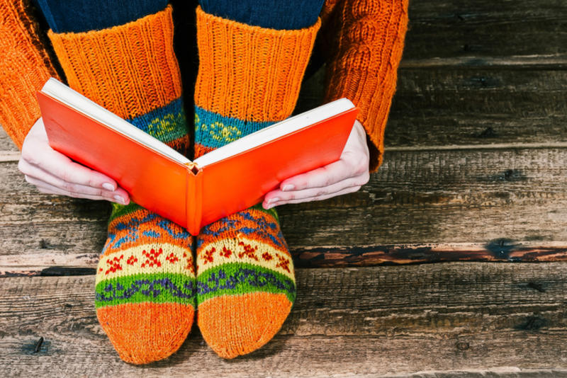 Person reading a book with colourful socks