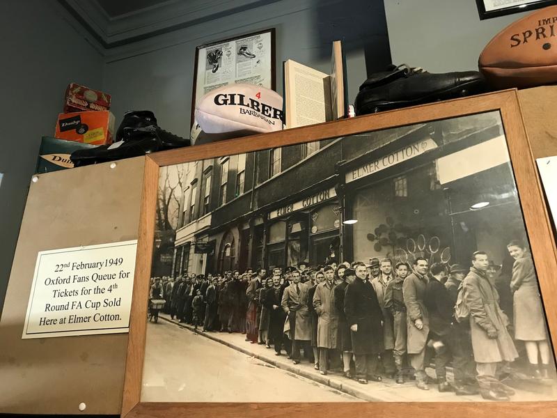 An old picture on display in the shop, which shows people queuing, with a note explaining the shop sold Oxford United FA Cup tickets in 1949