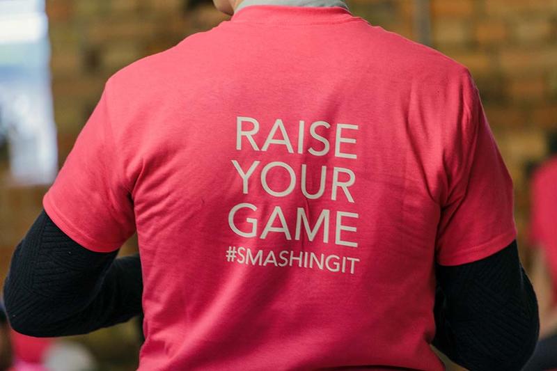 The back of an Oxford Foundry t-shirt, which reads 'Raise your game #smashingit'