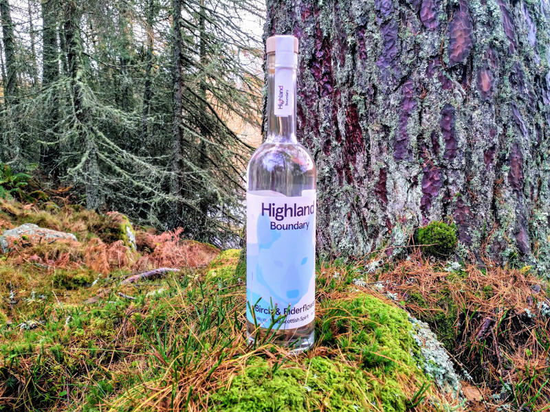 A bottle of Highland Boundary stood on a moss covered stone